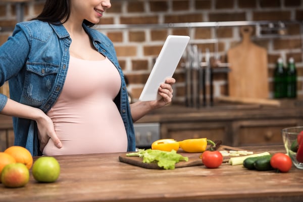 Pregnant woman reading recipe 