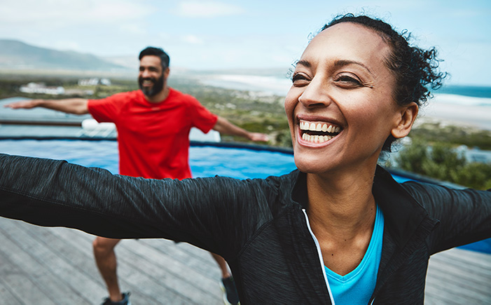 Couple smiling doing yoga and living a healthy lifestyle.