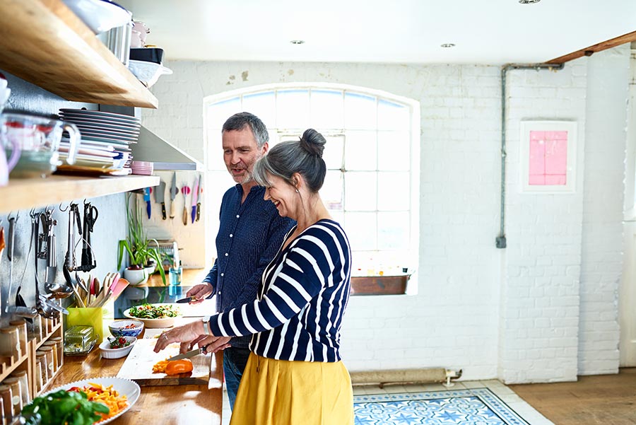 couple cutting veggies in kitchen