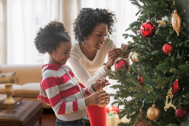 mother and daughter decorating Christmas tree